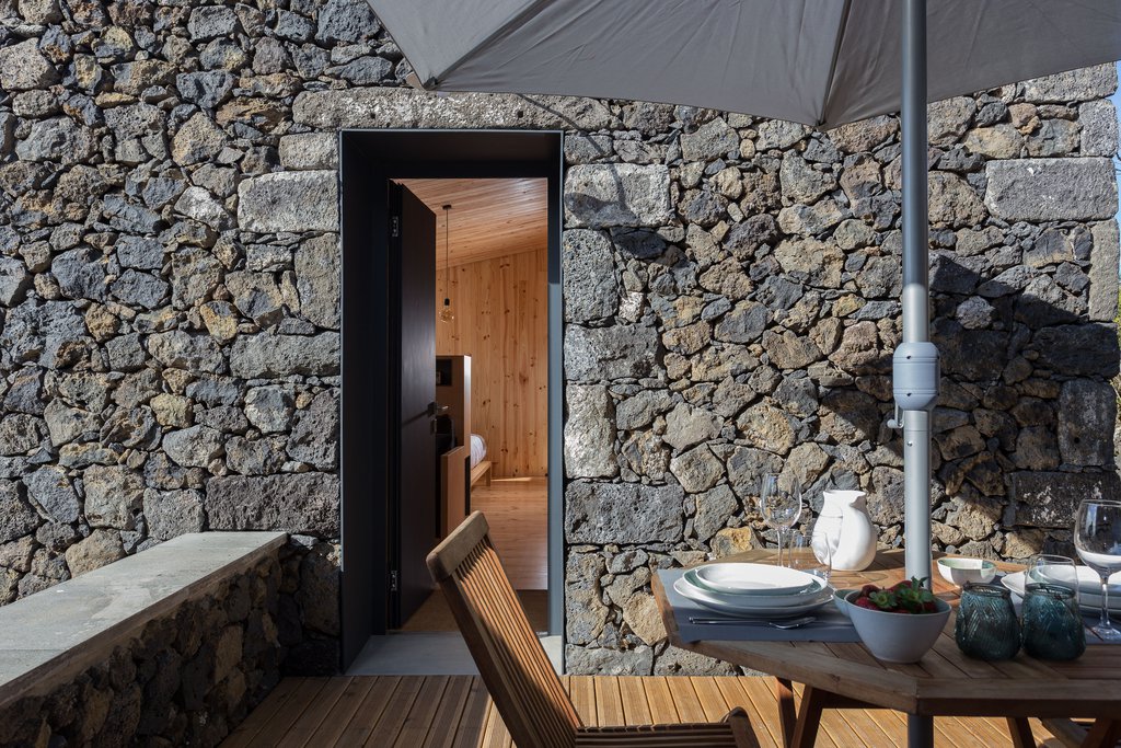 Studio accommodations/lodging at Quinta dos Peixes Falantes: exterior basalt façade entrance with private patio place setting