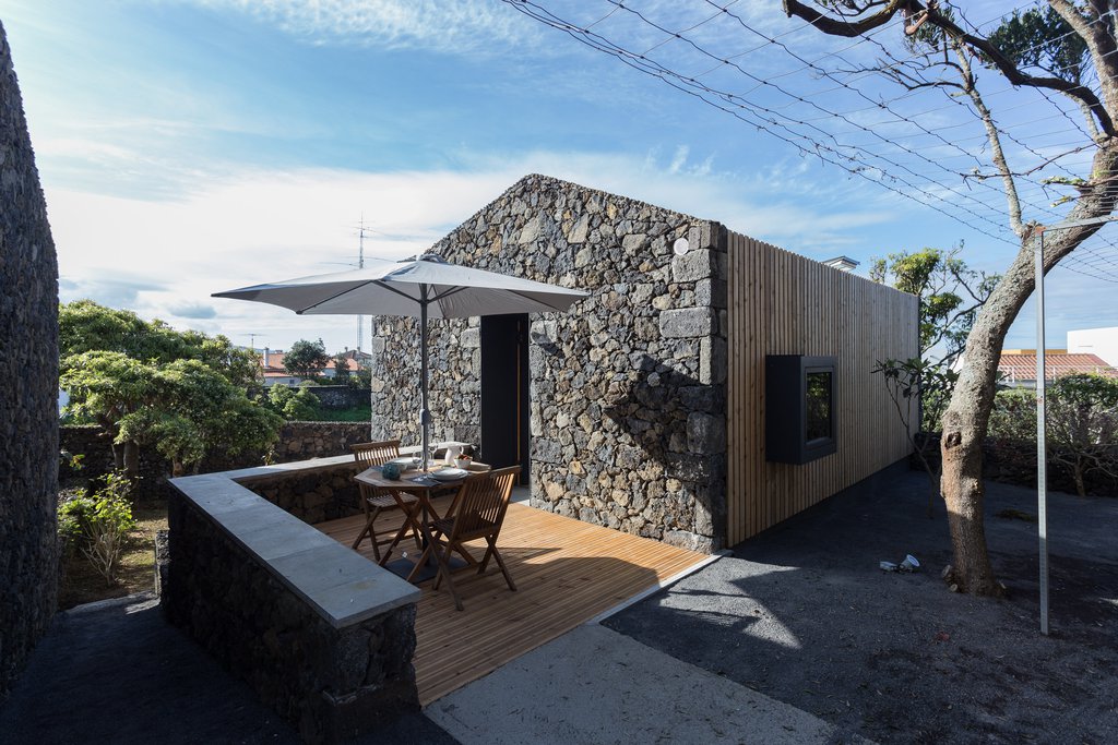 Studio accommodations/lodging at Quinta dos Peixes Falantes: exterior basalt façade entrance with private patio place setting