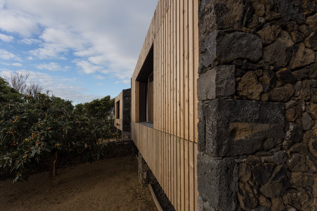 Studio accommodations/lodging at Quinta dos Peixes Falantes: exterior (lateral) view of facade finished in timbers slats and basalt corner