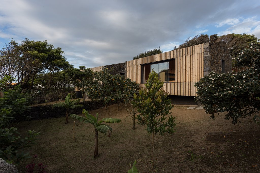 Studio accommodations/lodging at Quinta dos Peixes Falantes: exterior view of facade finished in timber slats, with private gardens